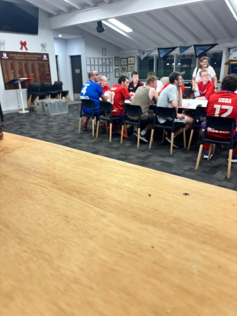 Hale Foundation participants gathered around tables at the Coolbinia West Perth Cricket Club for a team meeting before the game